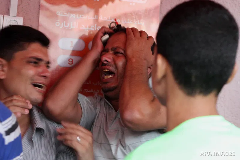 Palestinian relatives mourn on the body of Palestinian man, whom medics said was killed in an Israeli air strike, during his funeral in Khan Younis in the southern Gaza Strip August 26, 2014. Palestinian President Mahmou...