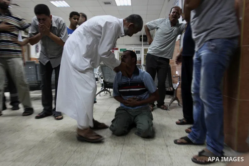 Palestinian relatives mourn on the body of Palestinian man, whom medics said was killed in an Israeli air strike, during his funeral in Khan Younis in the southern Gaza Strip August 26, 2014. Palestinian President Mahmou...