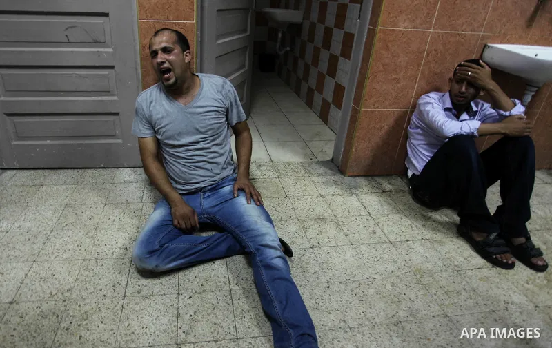 Palestinian relatives mourn on the body of Palestinian man, whom medics said was killed in an Israeli air strike, during his funeral in Khan Younis in the southern Gaza Strip August 26, 2014. Palestinian President Mahmou...