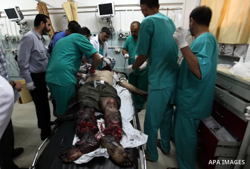 Palestinian medics gather around the body of Palestinian man, whom medics said was killed in an Israeli air strike, during his funeral in Khan Younis in the southern Gaza Strip August 26, 2014. Palestinian President Mahm...