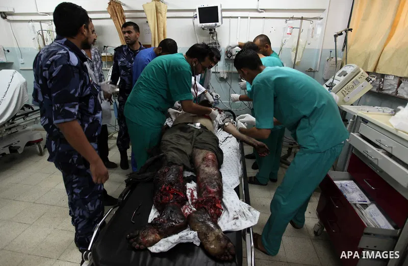 Palestinian medics gather around the body of Palestinian man, whom medics said was killed in an Israeli air strike, during his funeral in Khan Younis in the southern Gaza Strip August 26, 2014. Palestinian President Mahm...