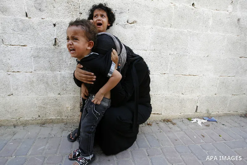 A woman and her kids react during the funeral of their relatives - two Palestinian children Mohammed and Oamr al-Brim who witnesses said were killed in an Israeli air strike before a ceasefire was declared, in Khan Youni...