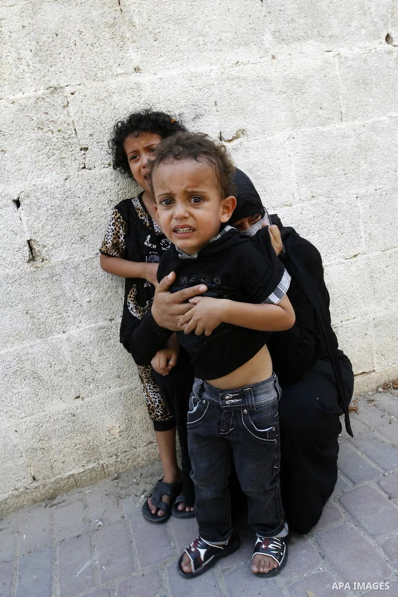 A woman and her kids react during the funeral of their relatives - two Palestinian children Mohammed and Oamr al-Brim who witnesses said were killed in an Israeli air strike before a ceasefire was declared, in Khan Youni...
