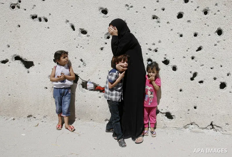 A woman and her kids react during the funeral of their relatives - two Palestinian children Mohammed and Oamr al-Brim who witnesses said were killed in an Israeli air strike before a ceasefire was declared, in Khan Youni...