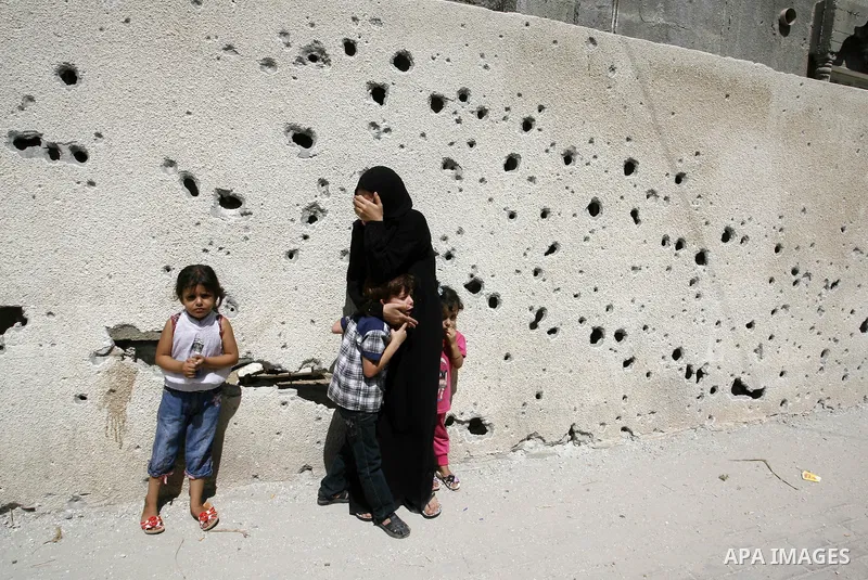 A woman and her kids react during the funeral of their relatives - two Palestinian children Mohammed and Oamr al-Brim who witnesses said were killed in an Israeli air strike before a ceasefire was declared, in Khan Youni...
