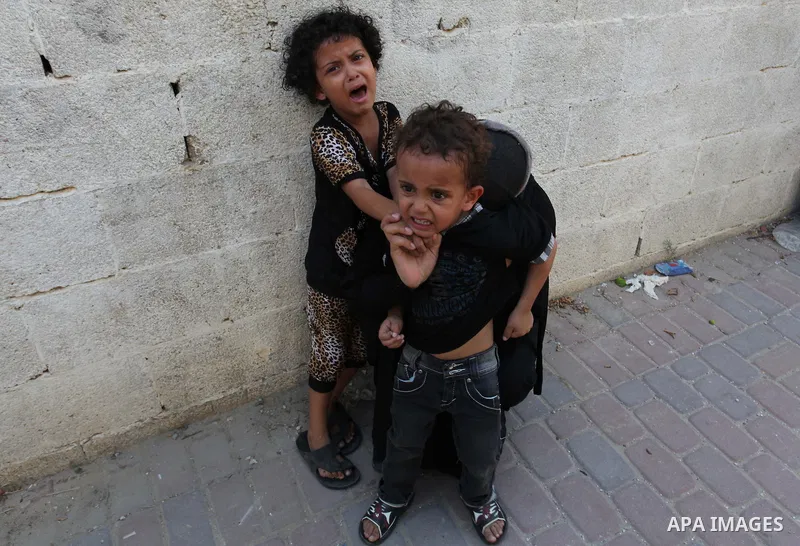 A woman and her kids react during the funeral of their relatives - two Palestinian children Mohammed and Omar al-Brim who witnesses said were killed in an Israeli air strike before a ceasefire was declared, in Khan Youni...