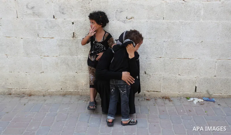 A woman and her kids react during the funeral of their relatives - two Palestinian children Mohammed and Omar al-Brim who witnesses said were killed in an Israeli air strike before a ceasefire was declared, in Khan Youni...