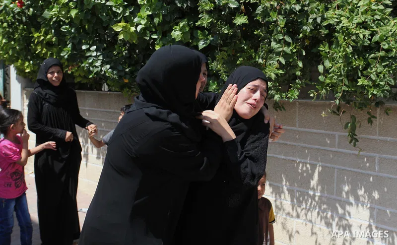 Relatives of two Palestinian children Mohammed and Omar al-Brim, who witnesses said were killed in an Israeli air strike before a ceasefire was declared, mourn during their funeral in Khan Younis in the southern Gaza Str...