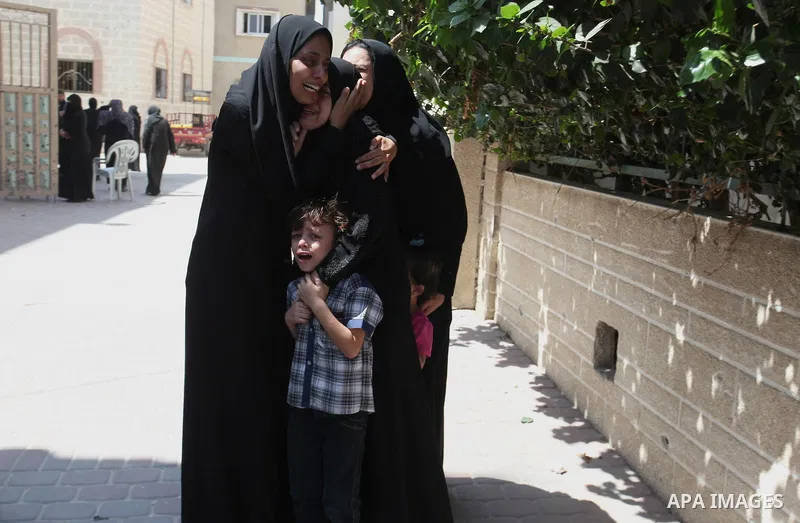 Relatives of two Palestinian children Mohammed and Omar al-Brim, who witnesses said were killed in an Israeli air strike before a ceasefire was declared, mourn during their funeral in Khan Younis in the southern Gaza Str...