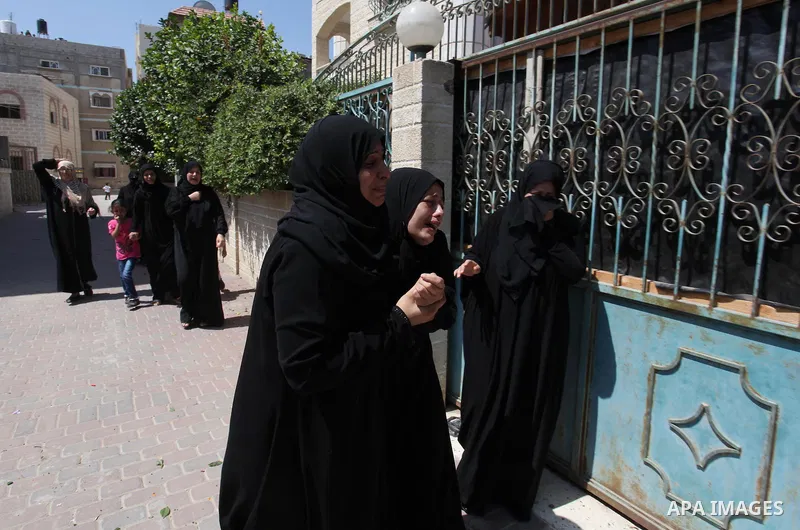 Relatives of two Palestinian children Mohammed and Omar al-Brim, who witnesses said were killed in an Israeli air strike before a ceasefire was declared, mourn during their funeral in Khan Younis in the southern Gaza Str...