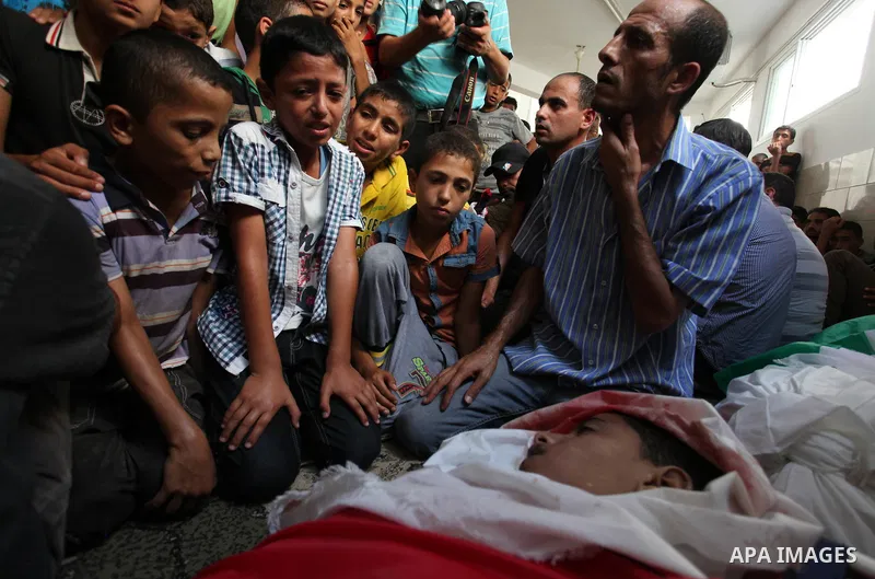 Mourners gather around the bodies of two Palestinian children Mohammed and Omar al-Brim who witnesses said were killed in an Israeli air strike before a ceasefire was declared, during their funeral in Khan Younis in the...