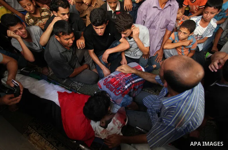 Mourners gather around the bodies of two Palestinian children Mohammed and Omar al-Brim who witnesses said were killed in an Israeli air strike before a ceasefire was declared, during their funeral in Khan Younis in the...