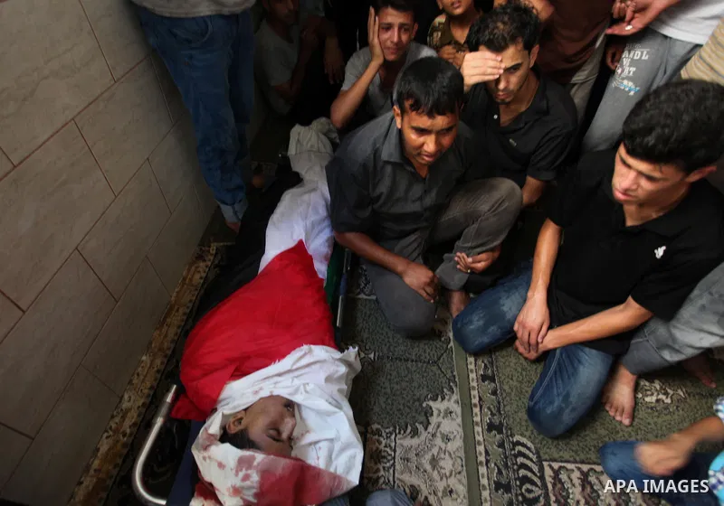 Mourners gather around the bodies of two Palestinian children Mohammed and Omar al-Brim who witnesses said were killed in an Israeli air strike before a ceasefire was declared, during their funeral in Khan Younis in the...