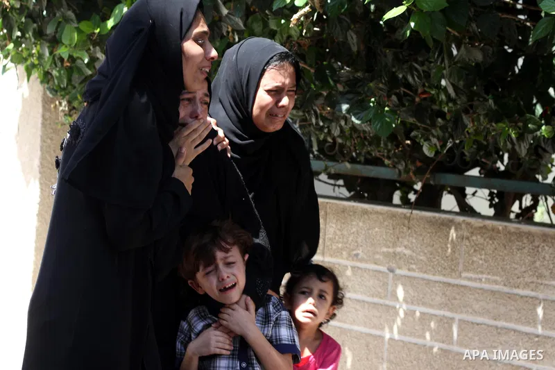 Relatives of two Palestinian children Mohammed and Omar al-Brim, who witnesses said were killed in an Israeli air strike before a ceasefire was declared, mourn during their funeral in Khan Younis in the southern Gaza Str...