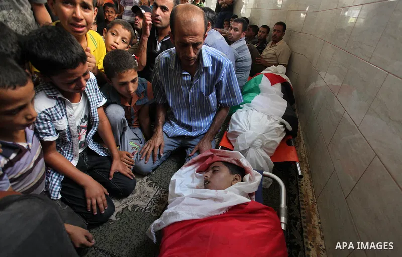 Mourners gather around the bodies of two Palestinian children Mohammed and Omar al-Brim who witnesses said were killed in an Israeli air strike before a ceasefire was declared, during their funeral in Khan Younis in the...