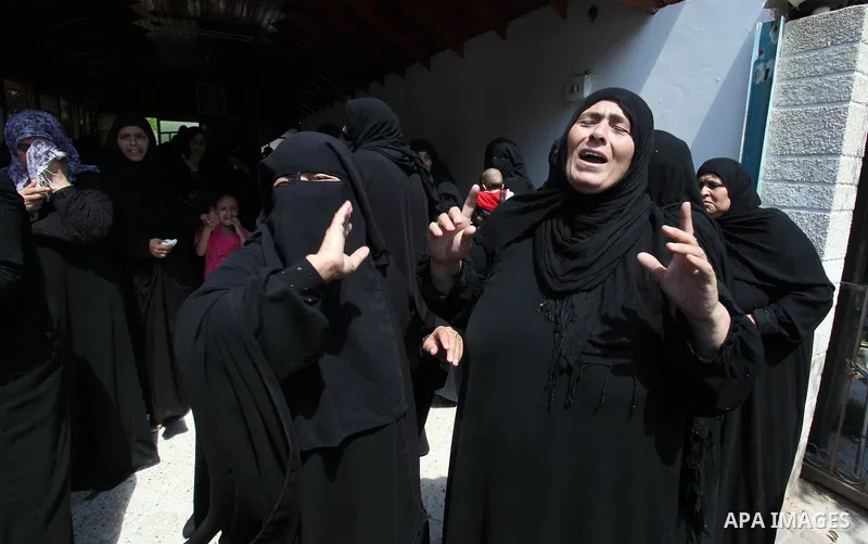 Relatives of two Palestinian children Mohammed and Omar al-Brim, who witnesses said were killed in an Israeli air strike before a ceasefire was declared, mourn during their funeral in Khan Younis in the southern Gaza Str...
