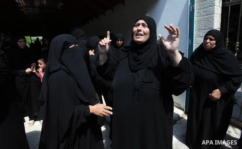 Relatives of two Palestinian children Mohammed and Omar al-Brim, who witnesses said were killed in an Israeli air strike before a ceasefire was declared, mourn during their funeral in Khan Younis in the southern Gaza Str...