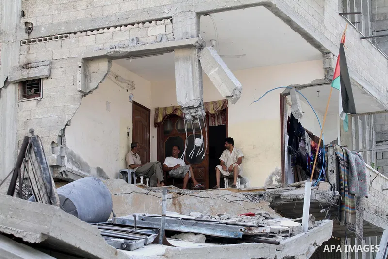 Palestinians sit on the rubble of their house, which witnesses said was destroyed in an Israeli offensive, after a ceasefire was declared, in the east of Gaza City August 27, 2014. The open-ended ceasefire in the Gaza wa...