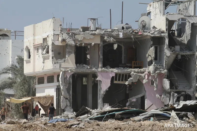 Palestinians sit under a tent as they return to the remains of their house, which witnesses said was destroyed in an Israeli offensive, after a ceasefire was declared, in the east of Gaza City August 27, 2014. The open-e...