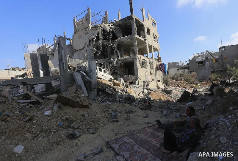 Palestinians sit on the rubble of their house, which witnesses said was destroyed in an Israeli offensive, after a ceasefire was declared, in the east of Gaza City August 27, 2014. The open-ended ceasefire in the Gaza wa...