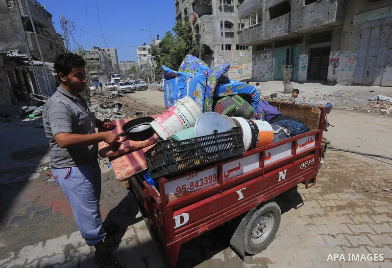 Palestinians collect their baggage as they prepare to return home in Gaza City's Shejaiya neighbourhood on August 27, 2014, following the long-term truce agreed between Israel and the Palestinians. The open-ended ceasefi...