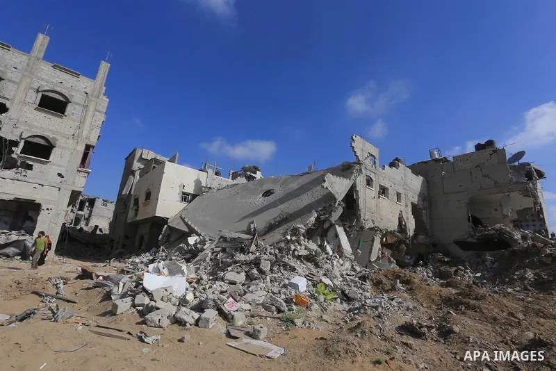 Palestinians walk past destroyed homes in their neighborhood as they head home in Shejaiya on August 27, 2014. The open-ended ceasefire in the Gaza war between Israel and the Palestinians held on Wednesday as Prime Minis...