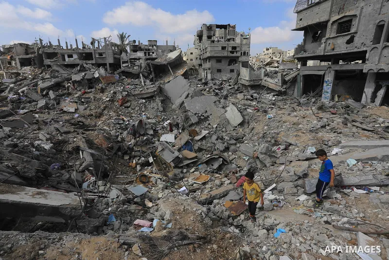 Palestinian boys walk on the rubble strewn ceiling of their family's home after she and other members of their family returned to their partially destroyed house early on August 27, 2014 in Gaza City's Shejaiya neighbour...