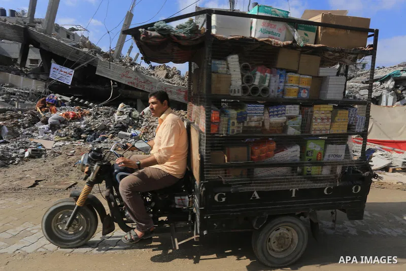 A Palestinian man collect his goods as he prepare to return home in Gaza City's Shejaiya neighbourhood on August 27, 2014, following the long-term truce agreed between Israel and the Palestinians. The open-ended ceasefir...