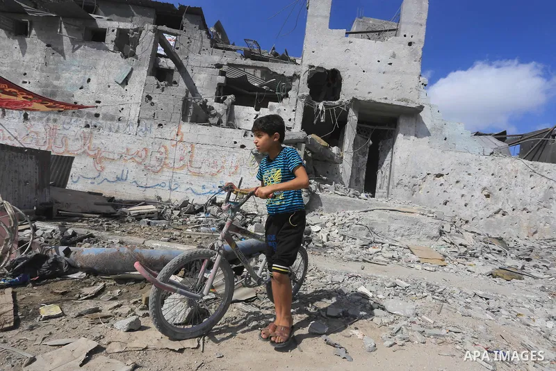 A Palestinian boy walks in a street on August 27, 2014 among houses destroyed in Gaza City's Shejaiya neighbourhood, which was one of the hardest hit hit by the fighting between Israel and Hamas militants. The open-ended...