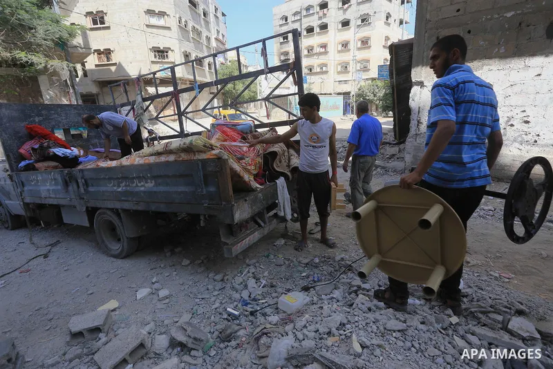 Palestinians collect their baggage as they prepare to return home in Gaza City's Shejaiya neighbourhood on August 27, 2014, following the long-term truce agreed between Israel and the Palestinians. The open-ended ceasefi...