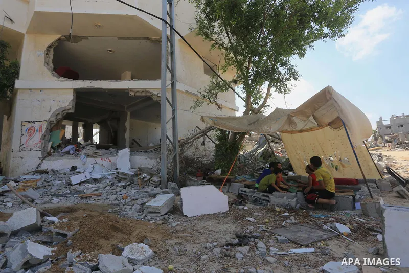 Palestinians sit under a tent as they return to the remains of their house, which witnesses said was destroyed in an Israeli offensive, after a ceasefire was declared, in the east of Gaza City August 27, 2014. The open-e...