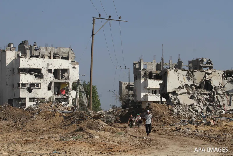 Palestinian men walk in a street on August 27, 2014 among houses destroyed in Gaza City's Shejaiya neighbourhood, which was one of the hardest hit hit by the fighting between Israel and Hamas militants. The open-ended ce...