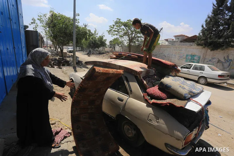 Palestinians collect their baggage as they prepare to return home in Gaza City's Shejaiya neighbourhood on August 27, 2014, following the long-term truce agreed between Israel and the Palestinians. The open-ended ceasefi...