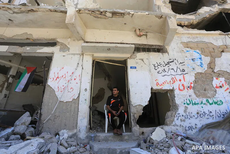 A Palestinian man sits on the rubble of his house, which witnesses said was destroyed in an Israeli offensive, after a ceasefire was declared, in the east of Gaza City August 27, 2014. The open-ended ceasefire in the Gaz...