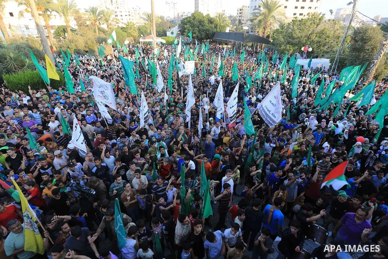 Palestinians wave Hamas flags as they celebrate in Gaza City on August 27, 2014, during a rally following a deal hailed by Israel and the Islamist movement as 'victory' in the 50-day war. The agreement, effective from 16...