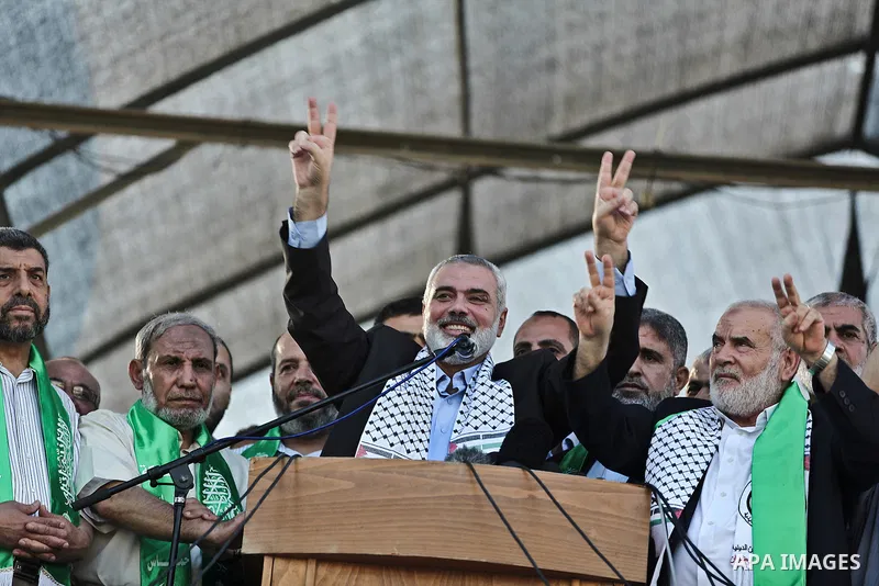 Hamas top leader in the Gaza Strip Ismail Haniya (C), standing next to Senior Hamas leader Mahmud al-Zahar (2nd from L), flashes the V-sign for "victory" during a rally in Gaza City on August 27, 2014, following a deal h...