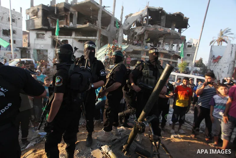 Palestinian militants of Izzedine al-Qassam Brigades, military wing of Hamas, and their supporters celebrate a victory rally at the debris of destroyed houses in Shijaiyah, neighborhood of Gaza City, in the northern Gaza...