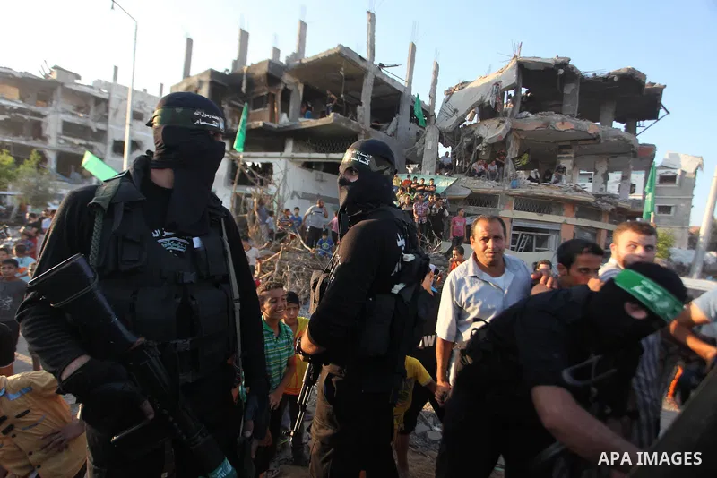 Palestinian militants of Izzedine al-Qassam Brigades, military wing of Hamas, and their supporters celebrate a victory rally at the debris of destroyed houses in Shijaiyah, neighborhood of Gaza City, in the northern Gaza...