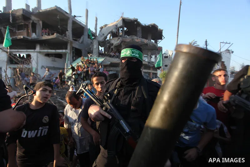 Palestinian militants of Izzedine al-Qassam Brigades, military wing of Hamas, and their supporters celebrate a victory rally at the debris of destroyed houses in Shijaiyah, neighborhood of Gaza City, in the northern Gaza...
