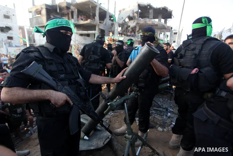 Palestinian militants of Izzedine al-Qassam Brigades, military wing of Hamas, and their supporters celebrate a victory rally at the debris of destroyed houses in Shijaiyah, neighborhood of Gaza City, in the northern Gaza...