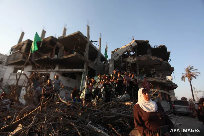 Palestinian militants of Izzedine al-Qassam Brigades, military wing of Hamas, and their supporters celebrate a victory rally at the debris of destroyed houses in Shijaiyah, neighborhood of Gaza City, in the northern Gaza...