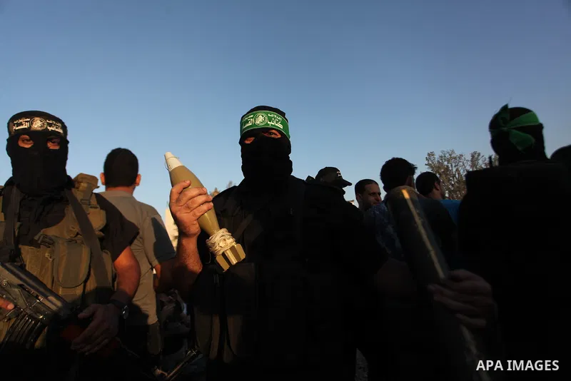 Palestinian militants of Izzedine al-Qassam Brigades, military wing of Hamas, and their supporters celebrate a victory rally at the debris of destroyed houses in Shijaiyah, neighborhood of Gaza City, in the northern Gaza...