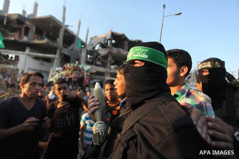 Palestinian militants of Izzedine al-Qassam Brigades, military wing of Hamas, and their supporters celebrate a victory rally at the debris of destroyed houses in Shijaiyah, neighborhood of Gaza City, in the northern Gaza...