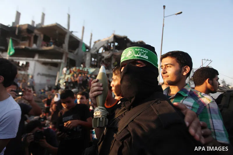 Palestinian militants of Izzedine al-Qassam Brigades, military wing of Hamas, and their supporters celebrate a victory rally at the debris of destroyed houses in Shijaiyah, neighborhood of Gaza City, in the northern Gaza...