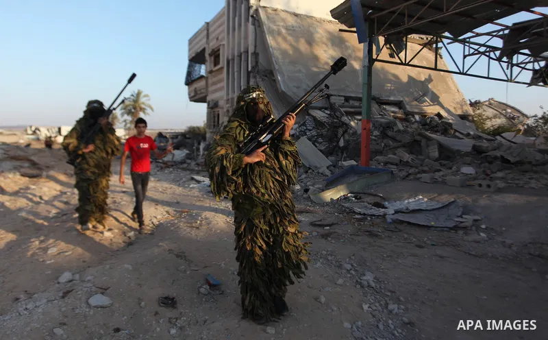 Palestinian militants of Izzedine al-Qassam Brigades, military wing of Hamas, and their supporters celebrate a victory rally at the debris of destroyed houses in Shijaiyah, neighborhood of Gaza City, in the northern Gaza...