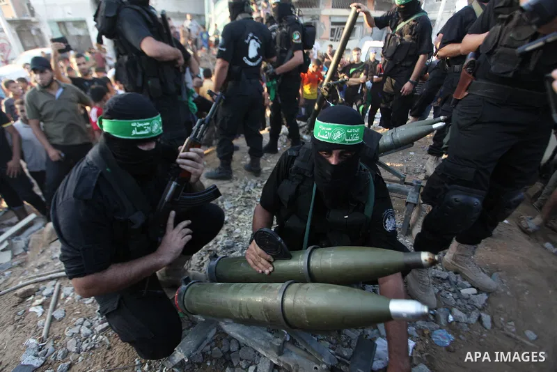Palestinian militants of Izzedine al-Qassam Brigades, military wing of Hamas, and their supporters celebrate a victory rally at the debris of destroyed houses in Shijaiyah, neighborhood of Gaza City, in the northern Gaza...