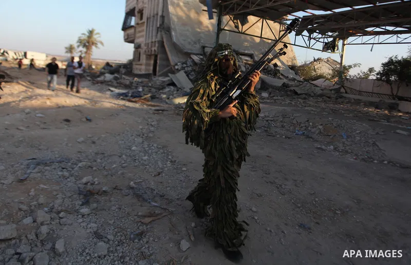 Palestinian militants of Izzedine al-Qassam Brigades, military wing of Hamas, and their supporters celebrate a victory rally at the debris of destroyed houses in Shijaiyah, neighborhood of Gaza City, in the northern Gaza...