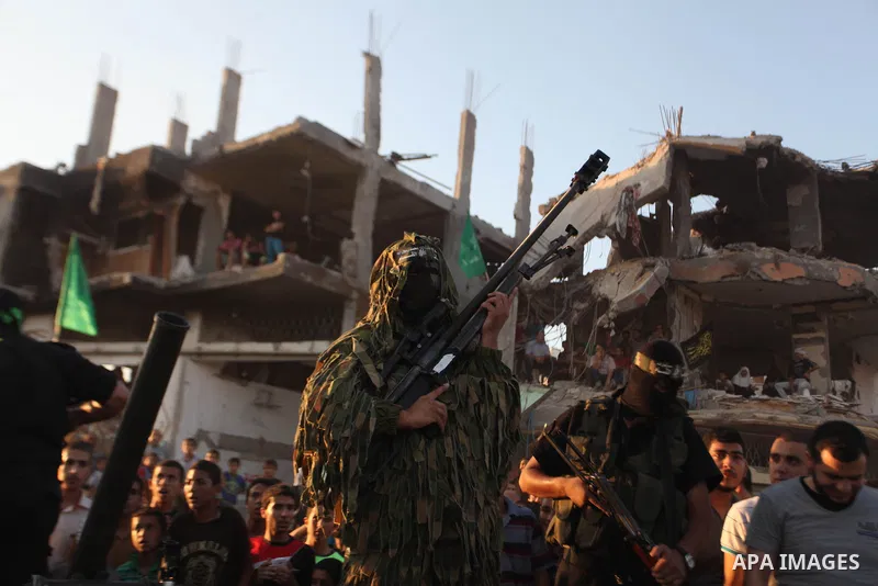 Palestinian militants of Izzedine al-Qassam Brigades, military wing of Hamas, and their supporters celebrate a victory rally at the debris of destroyed houses in Shijaiyah, neighborhood of Gaza City, in the northern Gaza...