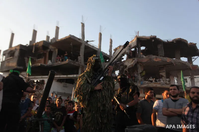 Palestinian militants of Izzedine al-Qassam Brigades, military wing of Hamas, and their supporters celebrate a victory rally at the debris of destroyed houses in Shijaiyah, neighborhood of Gaza City, in the northern Gaza...
