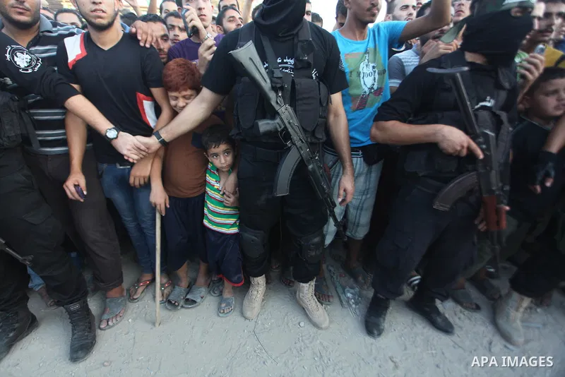 Palestinian militants of Izzedine al-Qassam Brigades, military wing of Hamas, and their supporters celebrate a victory rally at the debris of destroyed houses in Shijaiyah, neighborhood of Gaza City, in the northern Gaza...